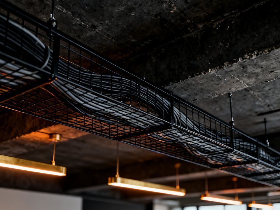 Bundled network cables in a cable tray under an office ceiling