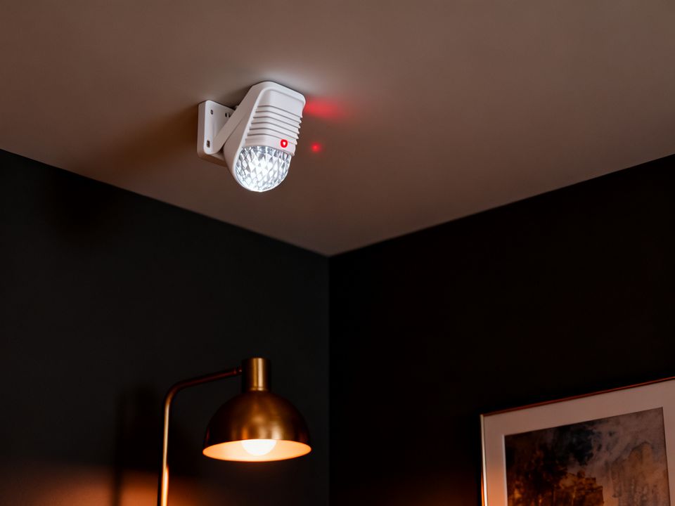Motion sensor with a red light in the corner of a living room